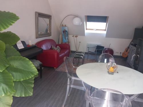 - un salon avec une table blanche et un canapé rouge dans l'établissement Ma gimeloise, à Gimel