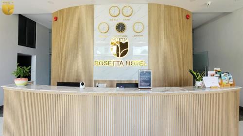 a lobby with a reception counter with a poster and clocks at Rosetta Hotel Phu Quoc in Phu Quoc