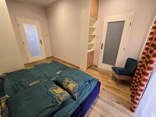 a bedroom with a green bed and a chair at Działkowa in Legnica
