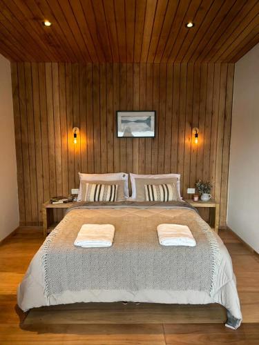 a bedroom with a large bed with two towels on it at Suite del muelle in San Carlos de Bariloche