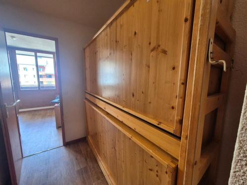 Cette chambre comprend une grande armoire en bois. dans l'établissement Studio cosy à Tignes Val Claret - 10m des pistes avec balcon, idéal pour 4 personnes - FR-1-502-429, à Tignes