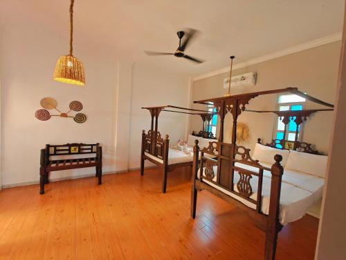a bedroom with two beds and a ceiling at Nungwi Roses in Nungwi