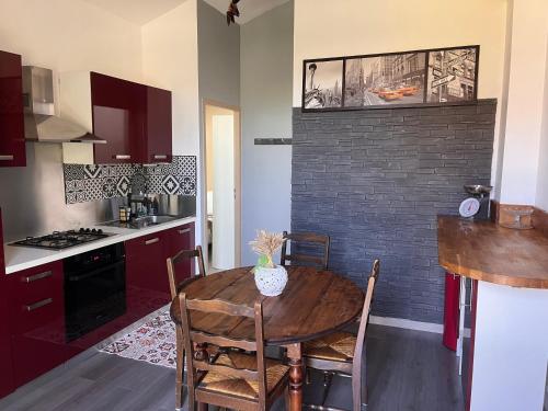 une cuisine avec une table en bois et un mur en briques dans l'établissement Gîte Appartement à la campagne, à Lautrec