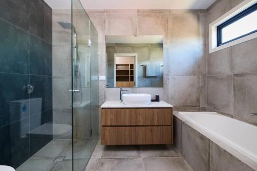 a bathroom with a sink and a glass shower at Preston Lux House 5 bed 5 bath in Melbourne