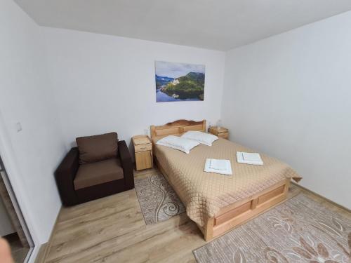 a small bedroom with a bed and a chair at Casa Toader in Gura Teghii