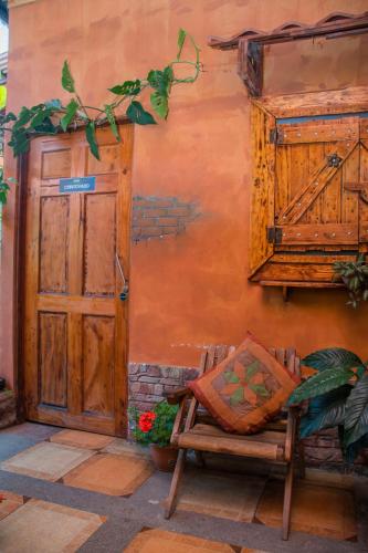 a wooden door and a bench in front of a building at Gardens House, Airport Juan Santamaría, Alajuela, San José in Alajuela City
