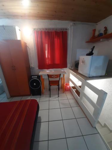 a small kitchen with a table and a red curtain at Mini House centro storico Duomo di Pavia in Pavia