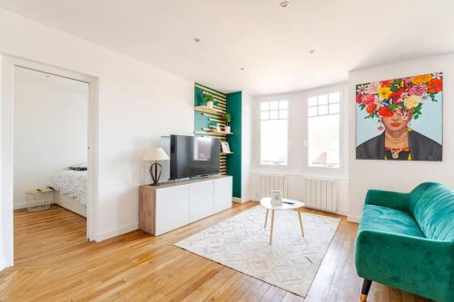 un salon avec un canapé et une télévision dans l'établissement Chantilly sauna relaxation, à Chantilly