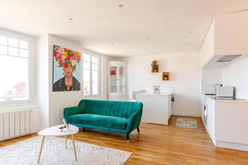 un salon avec un canapé vert et une cuisine dans l'établissement Chantilly sauna relaxation, à Chantilly