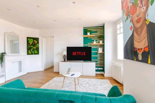 un salon avec un canapé bleu et une télévision dans l'établissement Chantilly sauna relaxation, à Chantilly