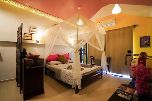 a bedroom with a bed with a canopy at Hidden Haven - The Goan Getaway in Dhamni