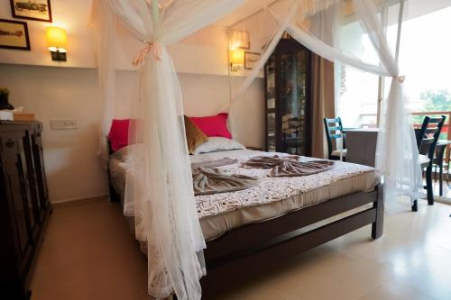 a bedroom with a bed with a mosquito net at Hidden Haven - The Goan Getaway in Dhamni