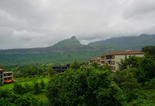 a view of a mountain with buildings and trees at Hidden Haven - The Goan Getaway in Dhamni