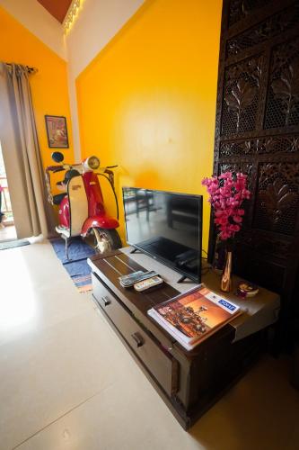 a living room with a tv on a wooden table at Hidden Haven - The Goan Getaway in Dhamni