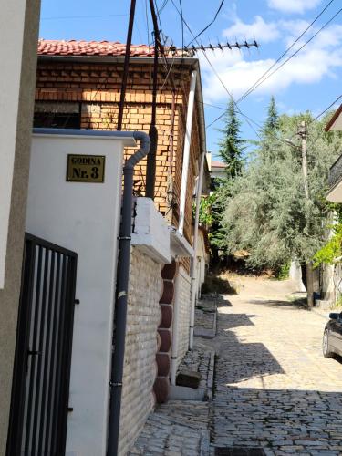a white door with a sign on the side of a building at Travelers' Korça Home in Korçë