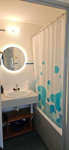 une salle de bain avec un lavabo et un rideau de douche dans l'établissement Le balcon du soleil, Pied de pistes 2100m 5 pers Plagne Soleil paradiski classé 2 étoiles meublé et 3 cristaux Paradiski, à La Plagne Tarentaise
