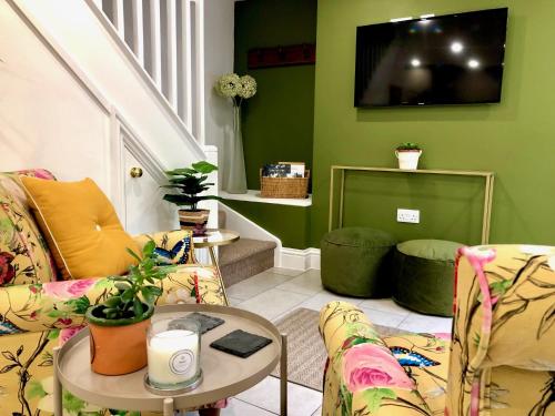 a living room with two couches and a table at Flower Cottage by Ludlow Castle with Onsite Parking in Ludlow