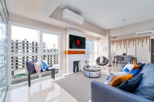 a living room with a blue couch and a fireplace at Luxury Condo Ocean View 1,2,3, & 4 Bedrooms Infinity Pool Gym Spa Next to Okada Solaire MOA NAIA Airport in Manila