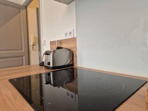 une cuisine avec un grille-pain assis sur un comptoir dans l'établissement l'Angevin - hypercentre - WiFi, à Sorges