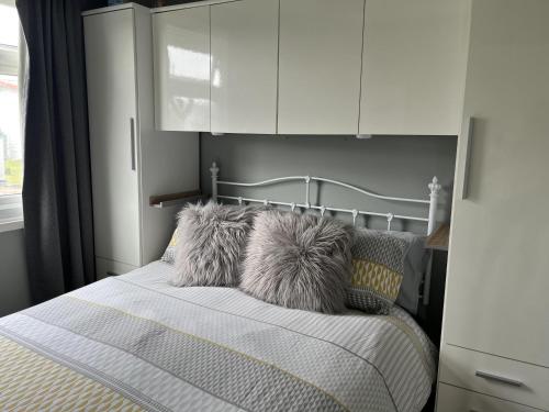 ブリドリントンにあるSeasideEscape-2Br-Sleeps4-Parking-PetsOK-Fireplaceのベッドルーム1室(白いキャビネットと枕付きのベッド1台付)