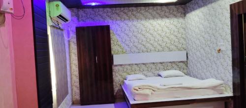 a room with a bed in a room with purple lights at Hotel Shri Sai International, Sitamarhi in Dumra