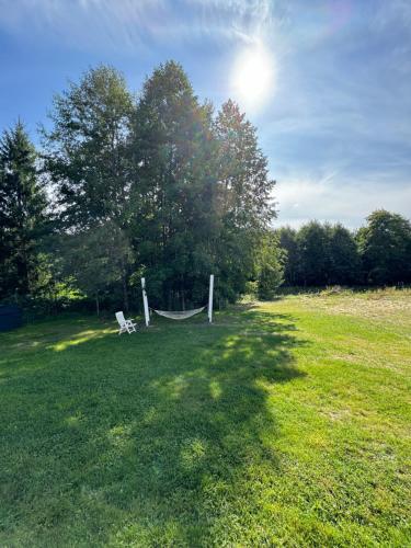 a hammock in the middle of a grass field at Domki Snopki in Pisz