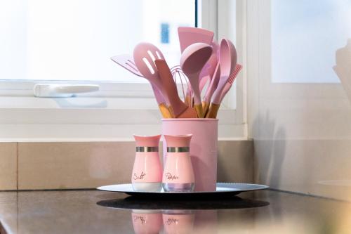 a plate with a pink container with utensils on a table at Luxury Condo Ocean View 1,2,3, & 4 Bedrooms Infinity Pool Gym Spa Next to Okada Solaire MOA NAIA Airport in Manila