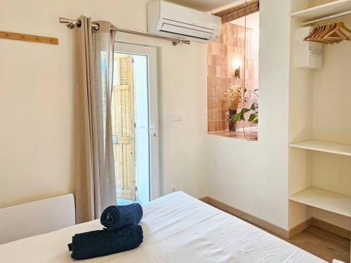 une chambre avec un lit blanc et une fenêtre dans l'établissement Cocon au cœur de Notre Dame, à Marseille