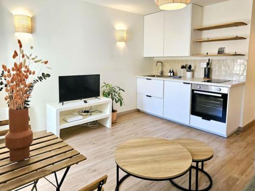 une cuisine avec des armoires blanches et une table en bois dans l'établissement Cocon au cœur de Notre Dame, à Marseille