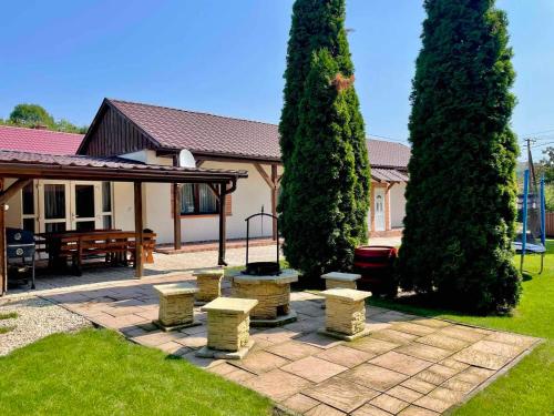 a patio with a group of trees and benches at Blanka Vendégház in Erdőbénye