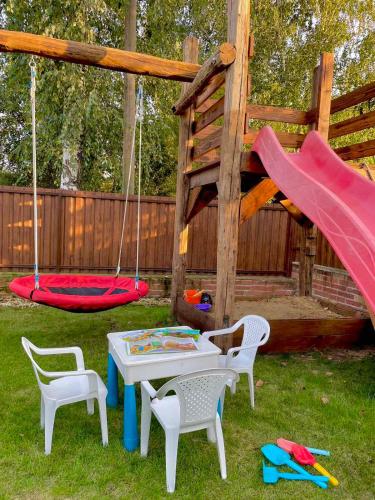 a playground with a table and chairs and swings at Blanka Vendégház in Erdőbénye