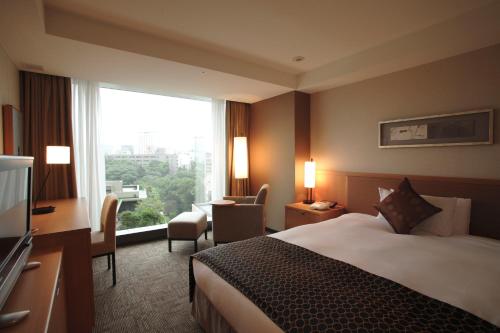 a hotel room with a bed and a large window at Hotel New Otani Tokyo The Main in Tokyo