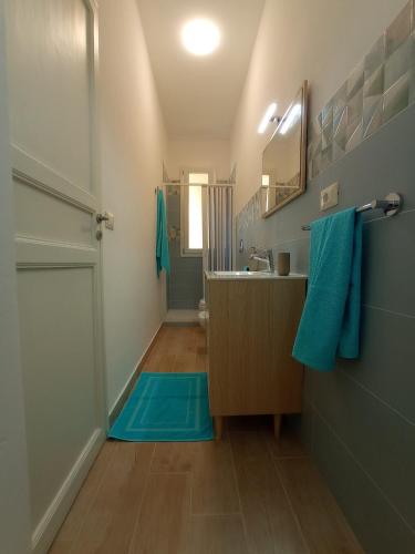 a bathroom with a sink and a blue rug at Casa Nenè in Trabia