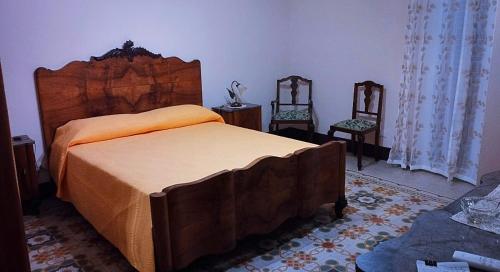 a bedroom with a large bed and two chairs at Casa Nenè in Trabia