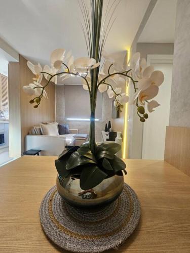 a vase filled with white flowers on a table at apartamento em prédio de luxo in Santo André