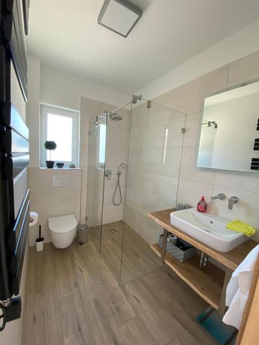 Un baño con ducha, lavabo e inodoro. en Villa Leonardo, en Tribunj