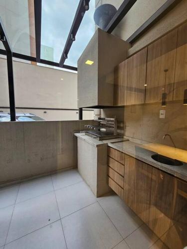 a large kitchen with wooden cabinets and a sink at apartamento em prédio de luxo in Santo André