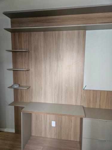 a kitchen with a counter and a wooden wall at apartamento em prédio de luxo in Santo André