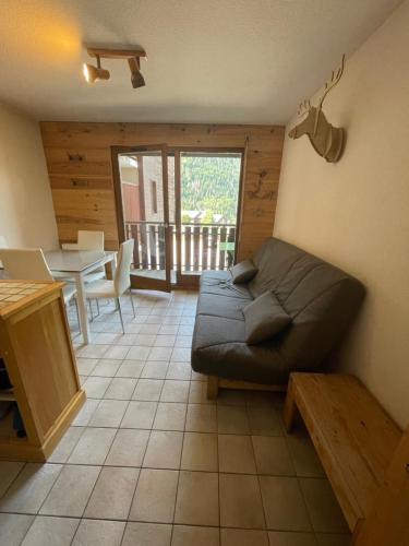 un salon avec un canapé et une table dans l'établissement Le Pied des Pistes A13, Joli Studio tout confort 4 pers, vue vallée imprenable, DRAPS NON COMPRIS, à Saint-Jean-dʼAulps