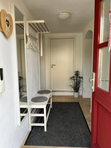 a room with a staircase and a red door at Allgäu Apartment in Memmingen