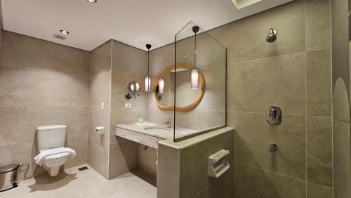 a bathroom with a toilet and a sink and a mirror at Hotel 59 in Marsa Matruh