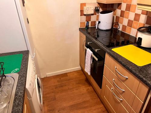 a kitchen with a stove top oven next to a sink at Bec Chambers NE 1 in Cramlington