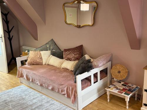 a room with a couch with a mirror on the wall at Le Grenier studio de charme centre historique in Dinan