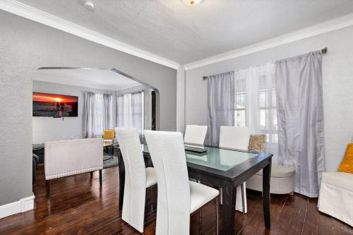 a dining room with a glass table and white chairs at Jazzy Charmer with 3 Queen BedsJazzy Charmer in Kansas City