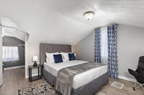 a bedroom with a bed and a chair and a window at Jazzy Charmer with 3 Queen BedsJazzy Charmer in Kansas City