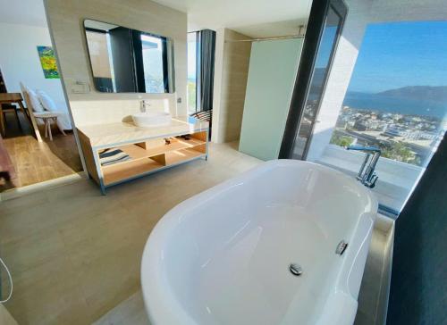 a white bath tub in a bathroom with a window at Villa Nha Trang Gần Biển - Biệt Thự Nha Trang Gần Biển in Nha Trang