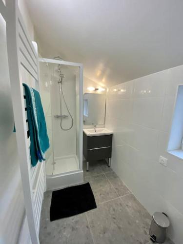 une salle de bain blanche avec une douche et un lavabo dans l'établissement Appartement rénover avec terrasse, à Creil