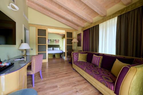 a living room with a couch and a table at Parc Hotel Flora S in Riva del Garda