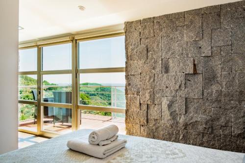 a bedroom with a stone wall and two towels on a bed at Entregredos in Guisando