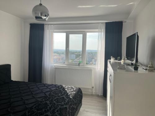 a bedroom with a bed and a large window at Apartment 2 camere 1,3 km Promenada Mall Capacitate 4 persoane in Craiova